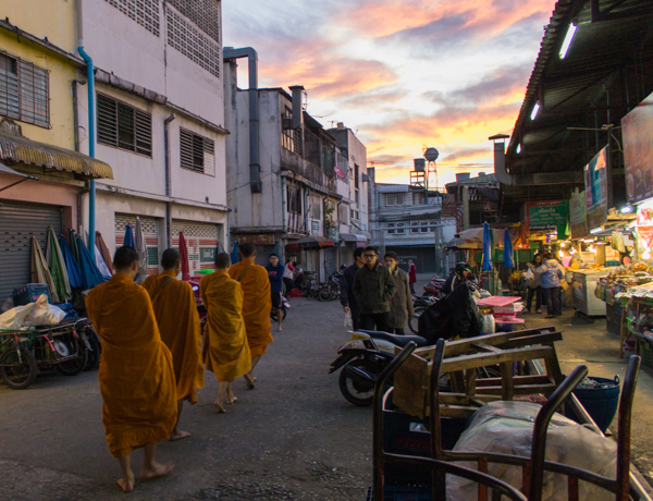Monks walking through the public market at sunrise. 